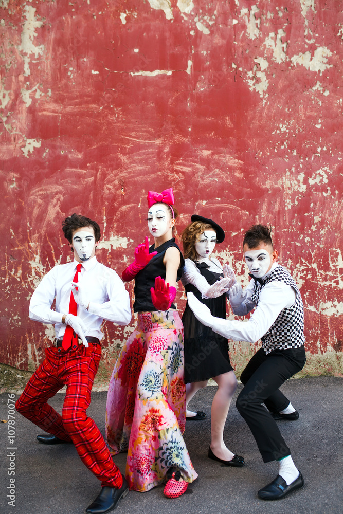 Obraz premium Four mimes standing in a fighting pose on a background of a red