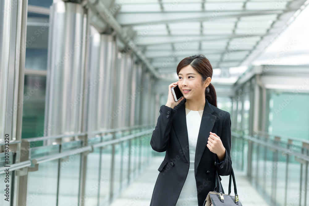 Businesswoman talk to mobile phone and walking at street Businesswoman talk to mobile phone and walking at street