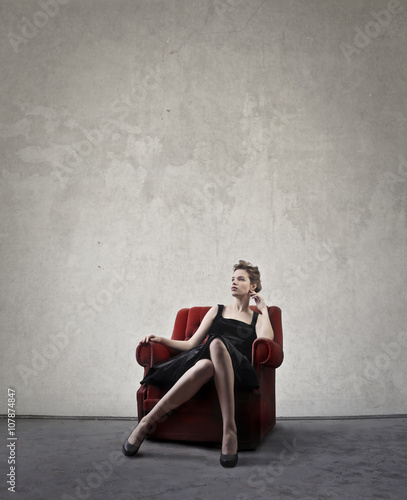 Model sitting in a red chair