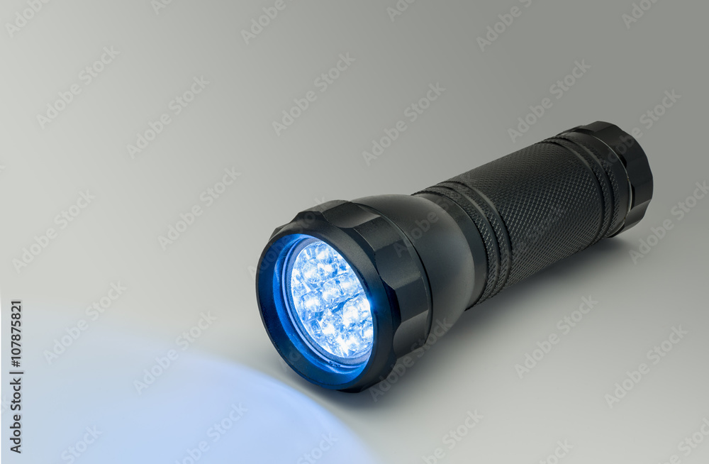 Black flashlight with blue LED light illumination Black flashlight with blue LED light illumination