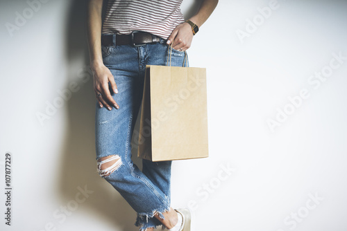Closeup of young and stylish woman with mockup of craft paper package