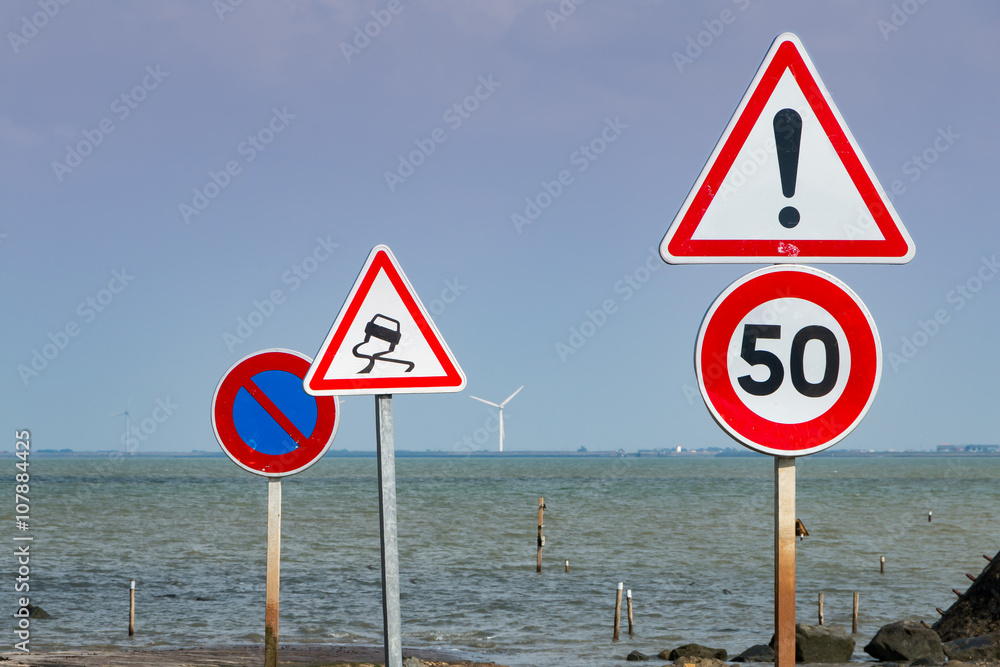 together of road signs next to sea
