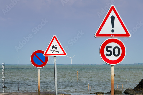 together of road signs next to sea