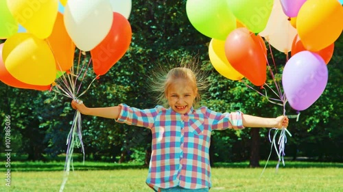 Colorful electrified hair girl and a large number of balloons. Sunlight and Lens flare