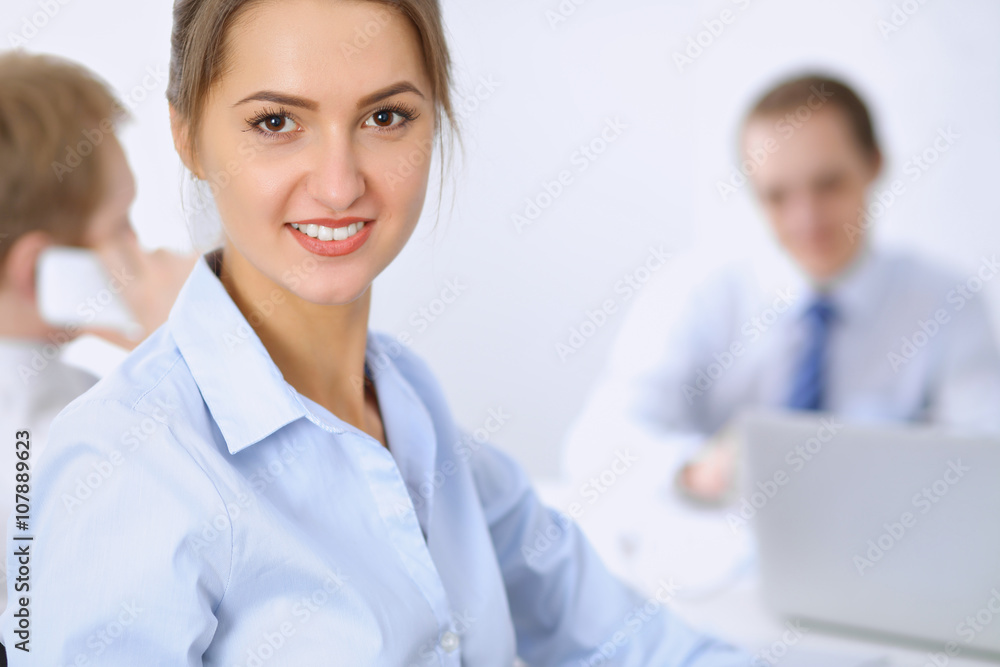 Beautiful business woman on the background of business people during meeting Beautiful business woman on the background of business people during meeting