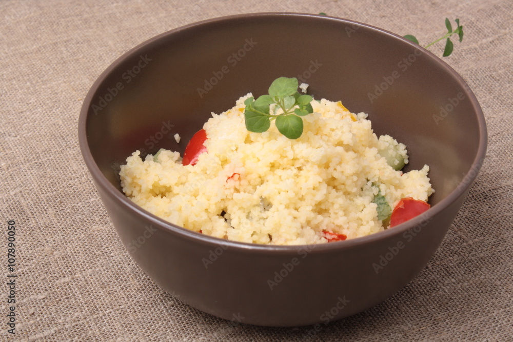 Couscous and roasted vegetables salad in a brown dish Couscous and roasted vegetables salad in a brown dish