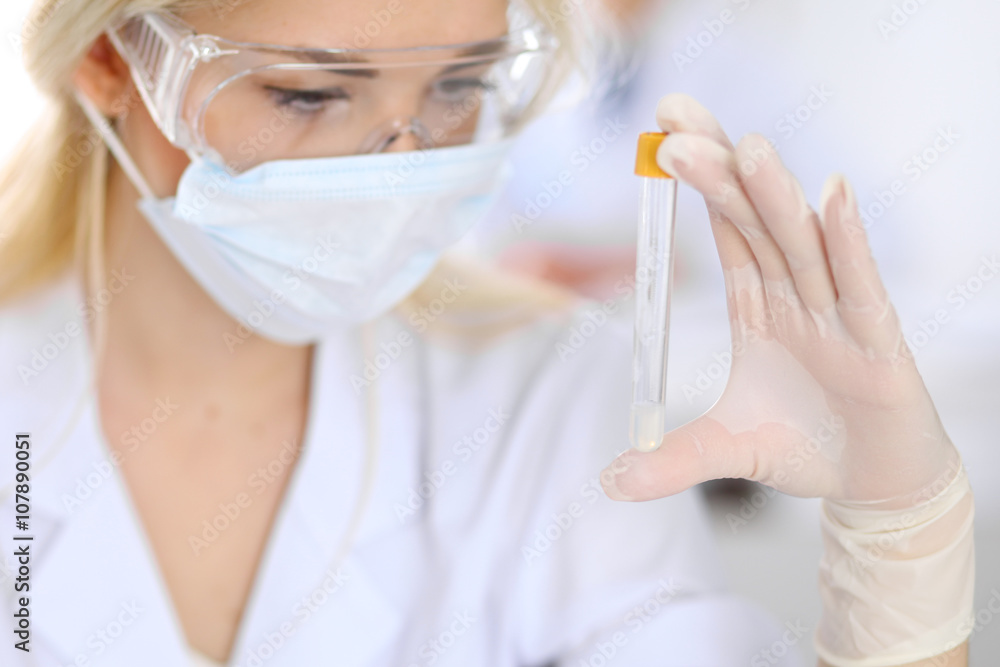 Female scientific research team with clear solution in laboratory Female scientific research team with clear solution in laboratory