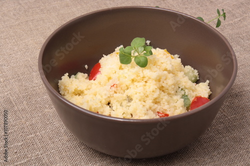 Couscous and roasted vegetables salad in a brown dish