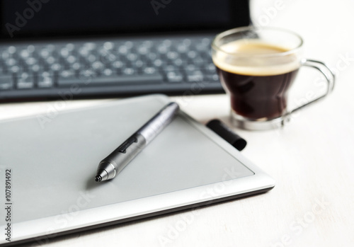 Digital tablet, stylus pen, tablet pad and cup of coffee. Select