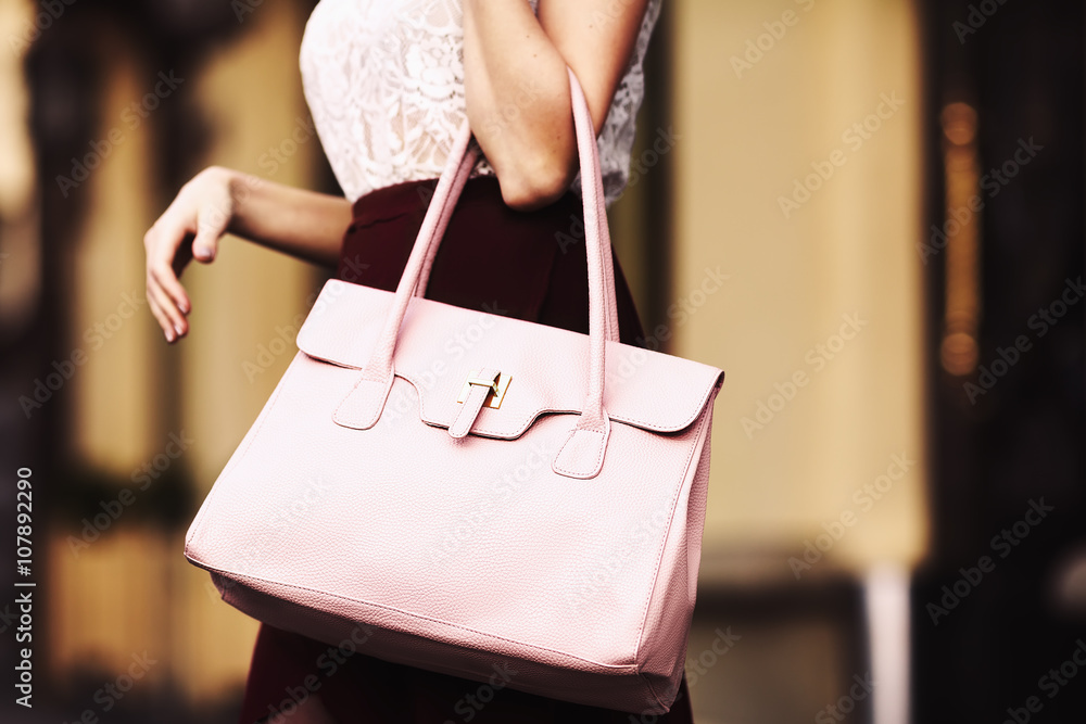 Elegant outfit. Closeup of leather bag in hands of stylish woman.  Fashionable girl on the street. Female fashion. City lifestyle. Toned  Photos | Adobe Stock
