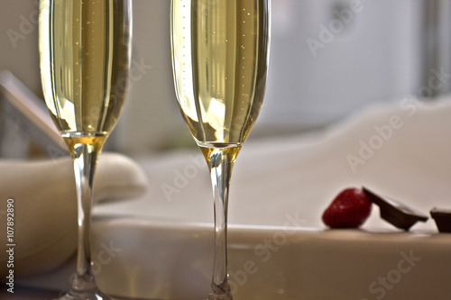 Two glasses of champagne near jacuzzi with strawberry and chocolate