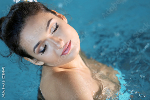 Beautiful young woman at swimming pool