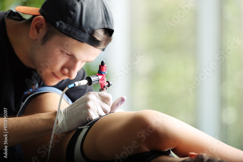 Tattooist makes tattoo, clo...