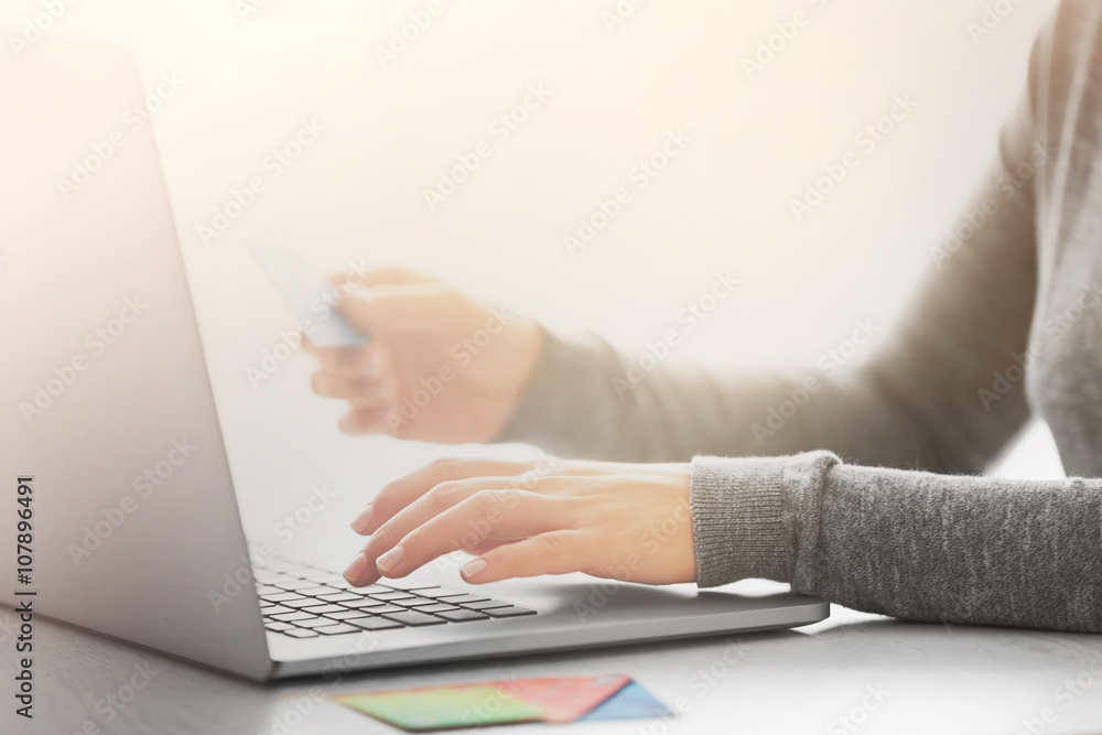 Fototapeta premium E-commerce concept. Woman with credit card and laptop, close up