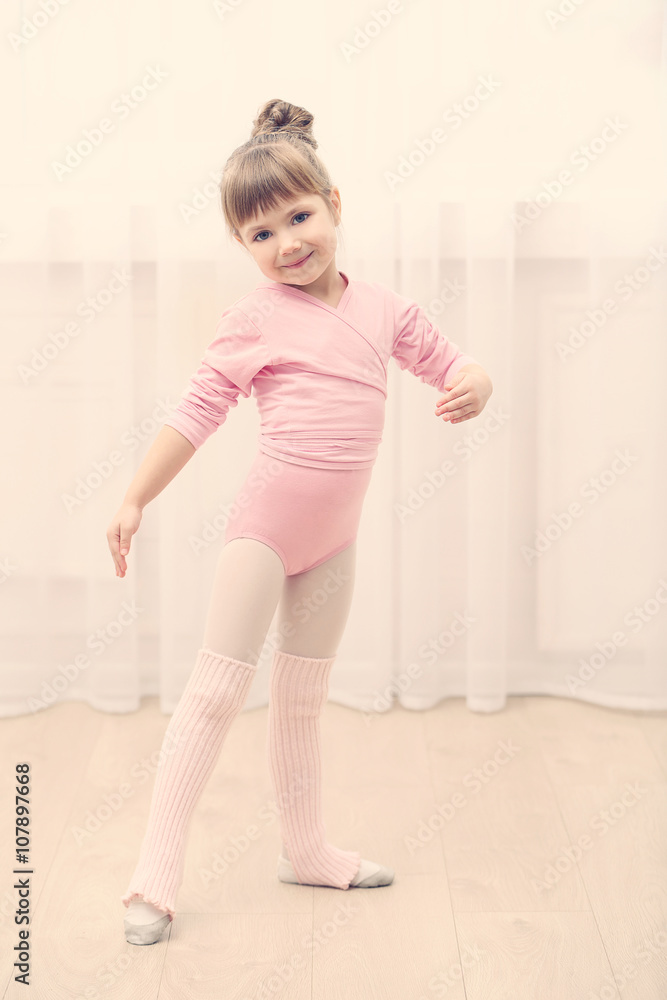Little cute girl in pink leotard making new ballet movement at dance studio Little cute girl in pink leotard making new ballet movement at dance studio