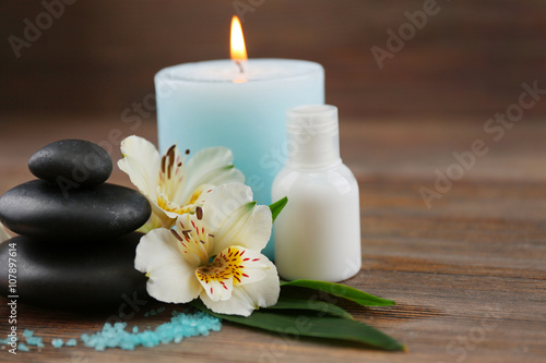 Spa still life with light blue candle on wooden background