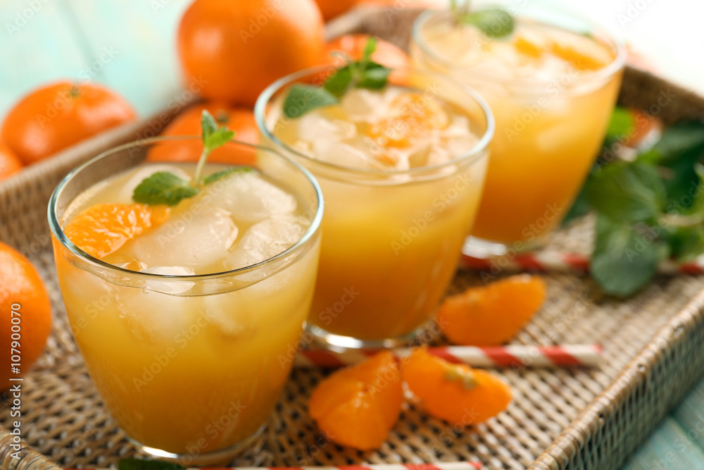 Fresh cocktails with ice, mint and tangerines on a wicker tray, close up Fresh cocktails with ice, mint and tangerines on a wicker tray, close up