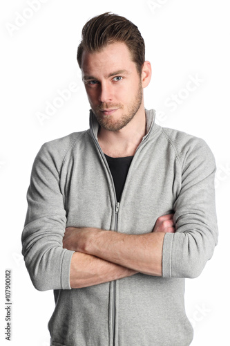 A man in his 20s wearing a grey shirt standing in front of a white background looking straight into camera.