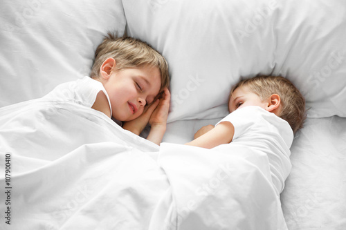Cute boys sleeping in bed u...