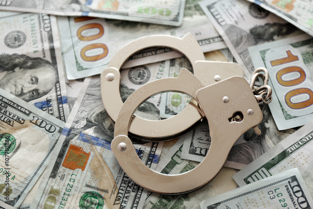 Handcuffs on dollar banknotes. Corruption concept Handcuffs on dollar banknotes. Corruption concept