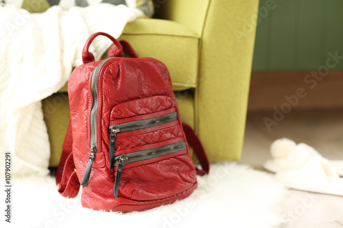 Red leather backpack on the floor.