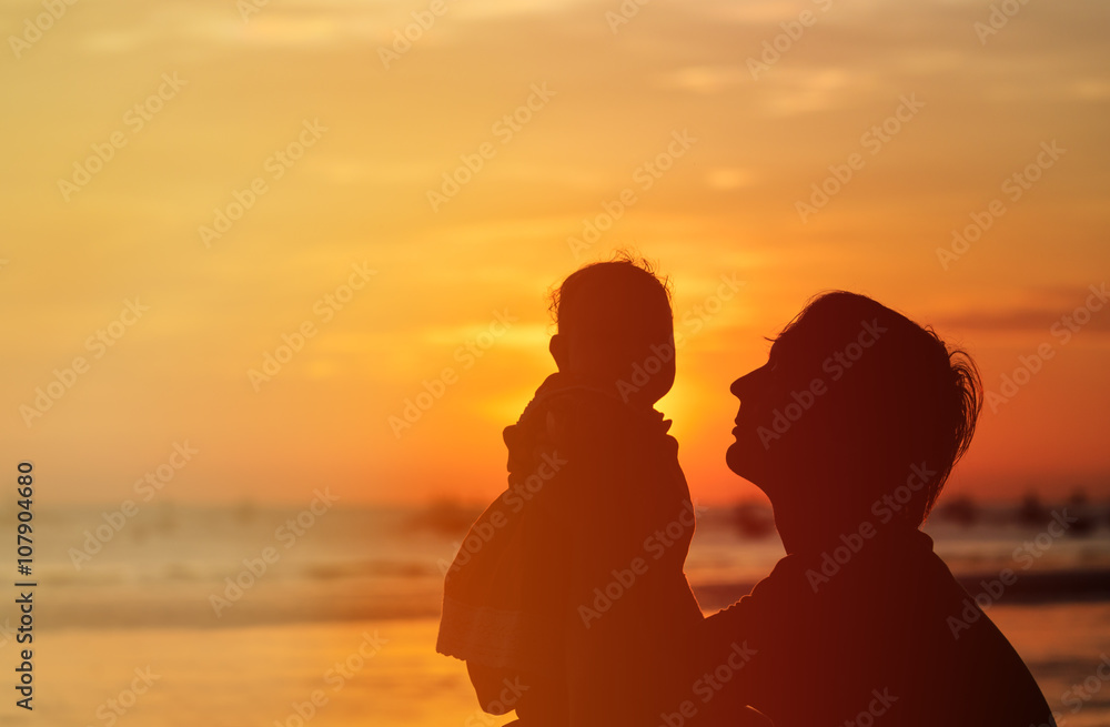 Father and little daughter silhouettes at sunset