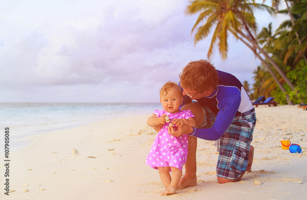 father and little daughter playing on beach