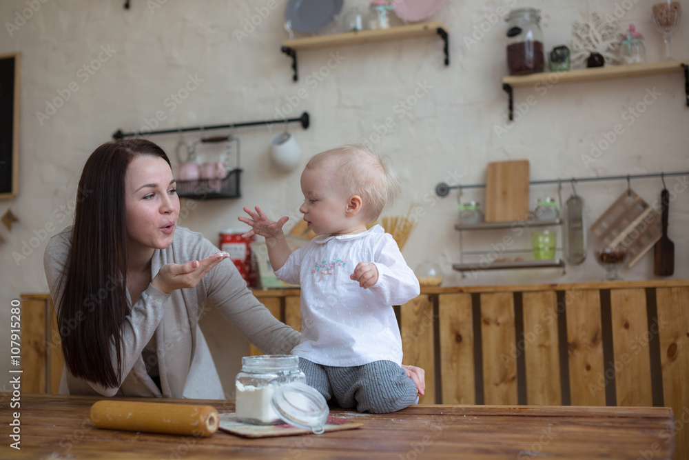 mother with her baby daughter in kitchen together cooking, lifes mother with her baby daughter in kitchen together cooking, lifes