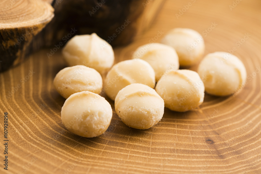 Roasted Macadamia nuts on rustic wooden background Roasted Macadamia nuts on rustic wooden background