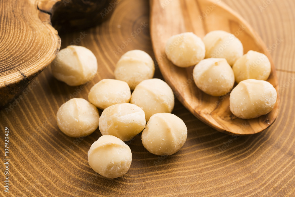 Roasted Macadamia nuts on rustic wooden background
