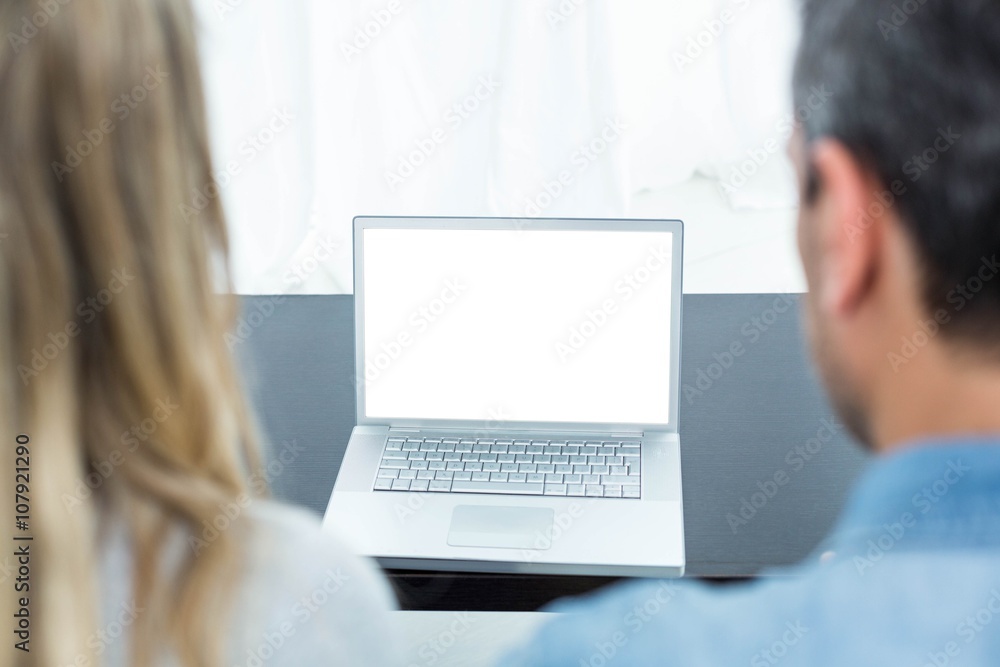 Couple using laptop in living room Couple using laptop in living room