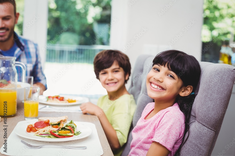 Smiling children sitting at dining table 