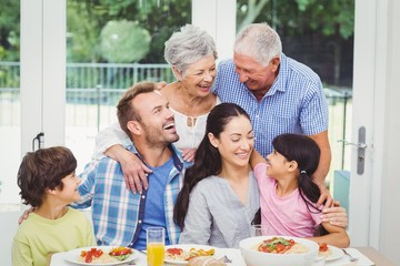 Smiling multi generation family at dining table