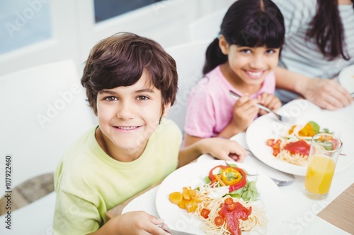 Portrait of smiling children having food 