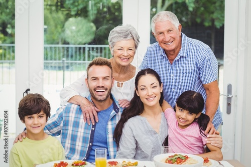 Portrait of smiling multi generation family at dining table 
