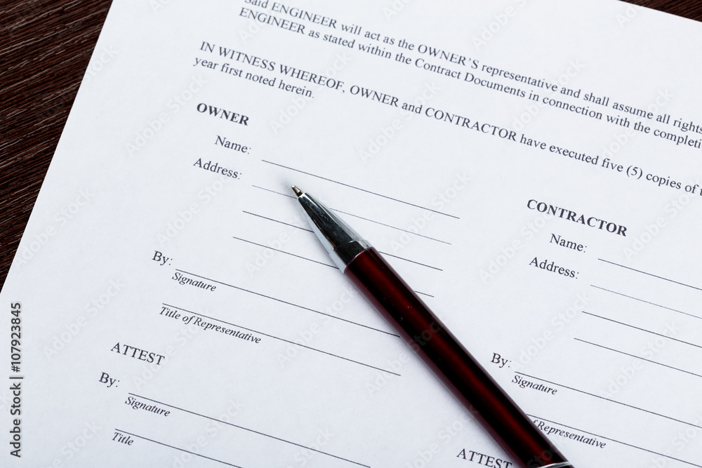 Pen and contract papers on wooden desk Pen and contract papers on wooden desk