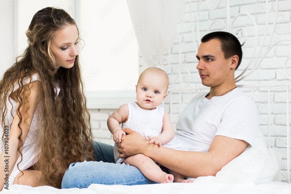 Mother and father with little baby in a bed Mother and father with little baby in a bed