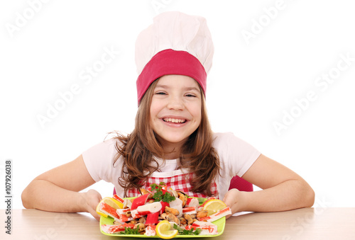 happy little girl cook with seafood on table