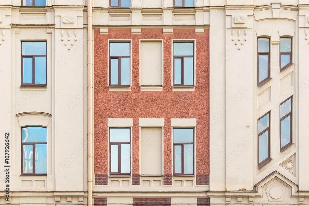 Several windows in row on facade of urban apartment building front view, St. Petersburg, Russia.