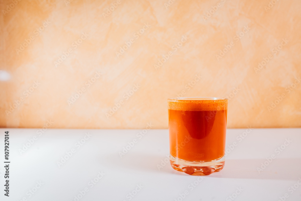 Glasses of carrot juice with vegetables on table close up Glasses of carrot juice with vegetables on table close up
