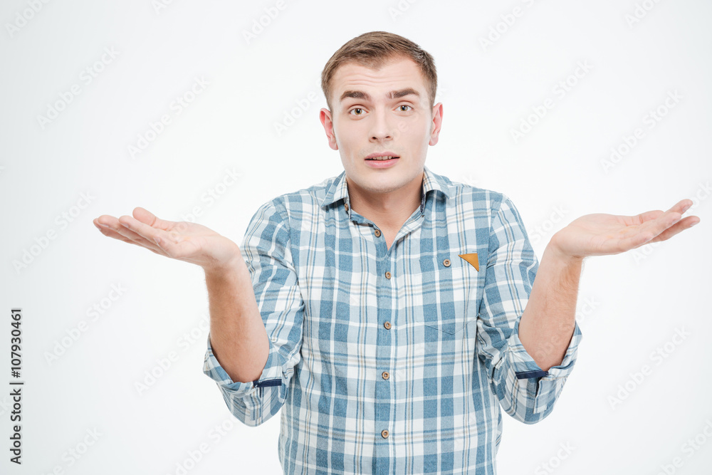 Confused handsome young man holding copuspace on both palms Confused handsome young man holding copuspace on both palms
