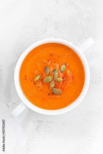 colorful pumpkin cream soup on a white background, top view