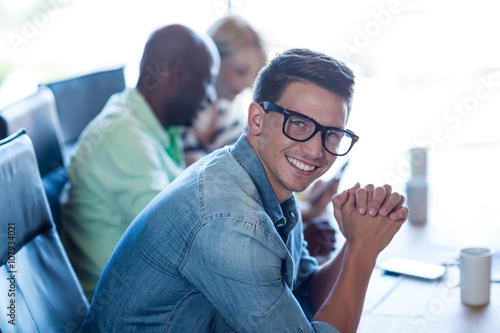 Young man sitting at his desk smiling at camera © WavebreakMediaMicro