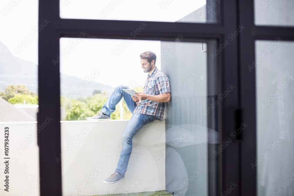 Man sitting on terrace using digital tablet Man sitting on terrace using digital tablet