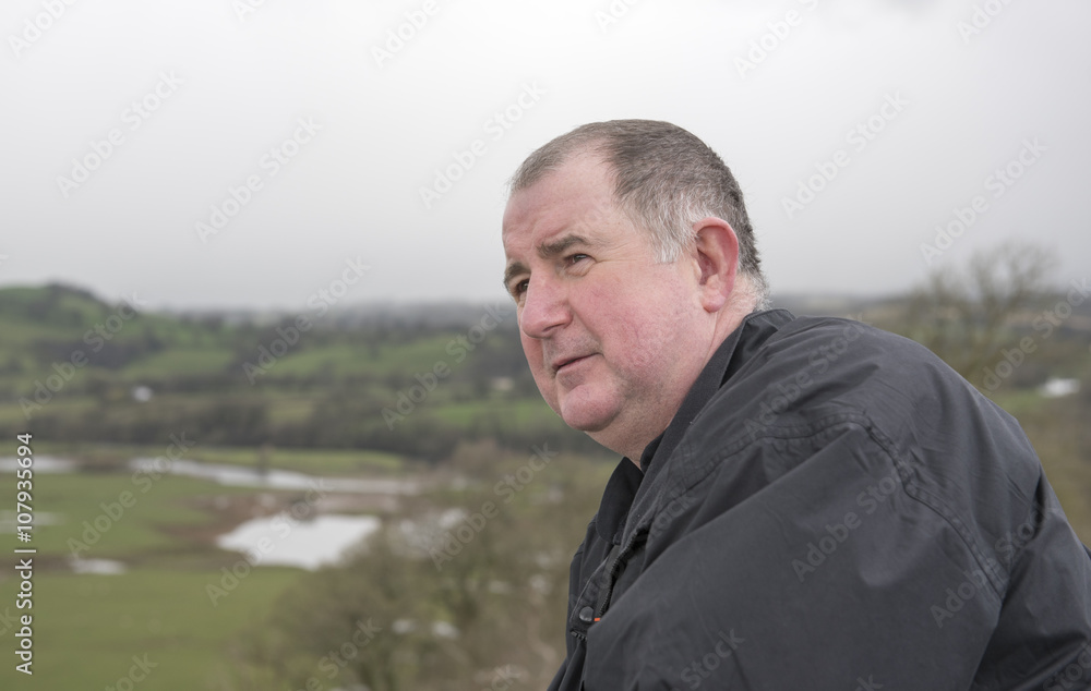 Portrait image of a mature man looking out, over a view. Portrait image of a mature man looking out, over a view.