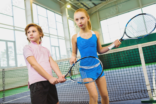 Children playing tennis and posing indoor © dreamsnavigator