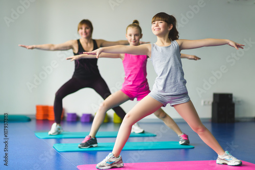Girls and Instructor or mother doing gymnastic exercises in fitness class