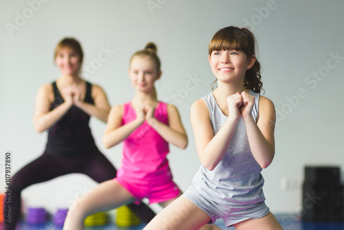 Girls and Instructor or mother doing gymnastic exercises  in fitness class © dreamsnavigator
