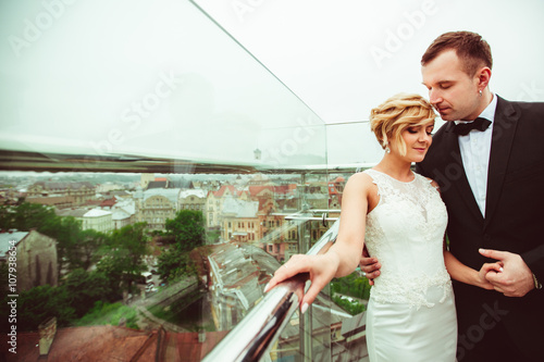 groom holds the hand of his charming woman photo