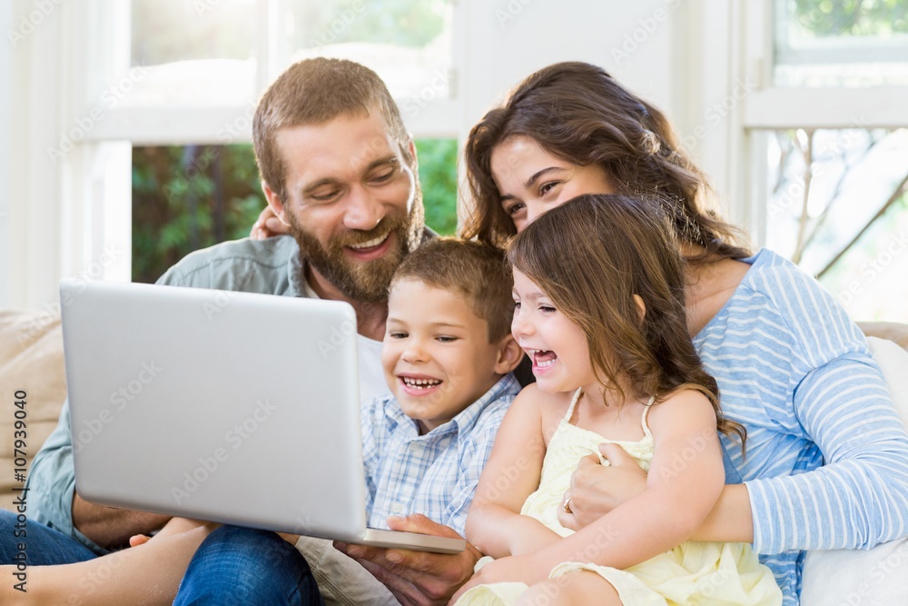 Parents and kids using laptop in living room Parents and kids using laptop in living room
